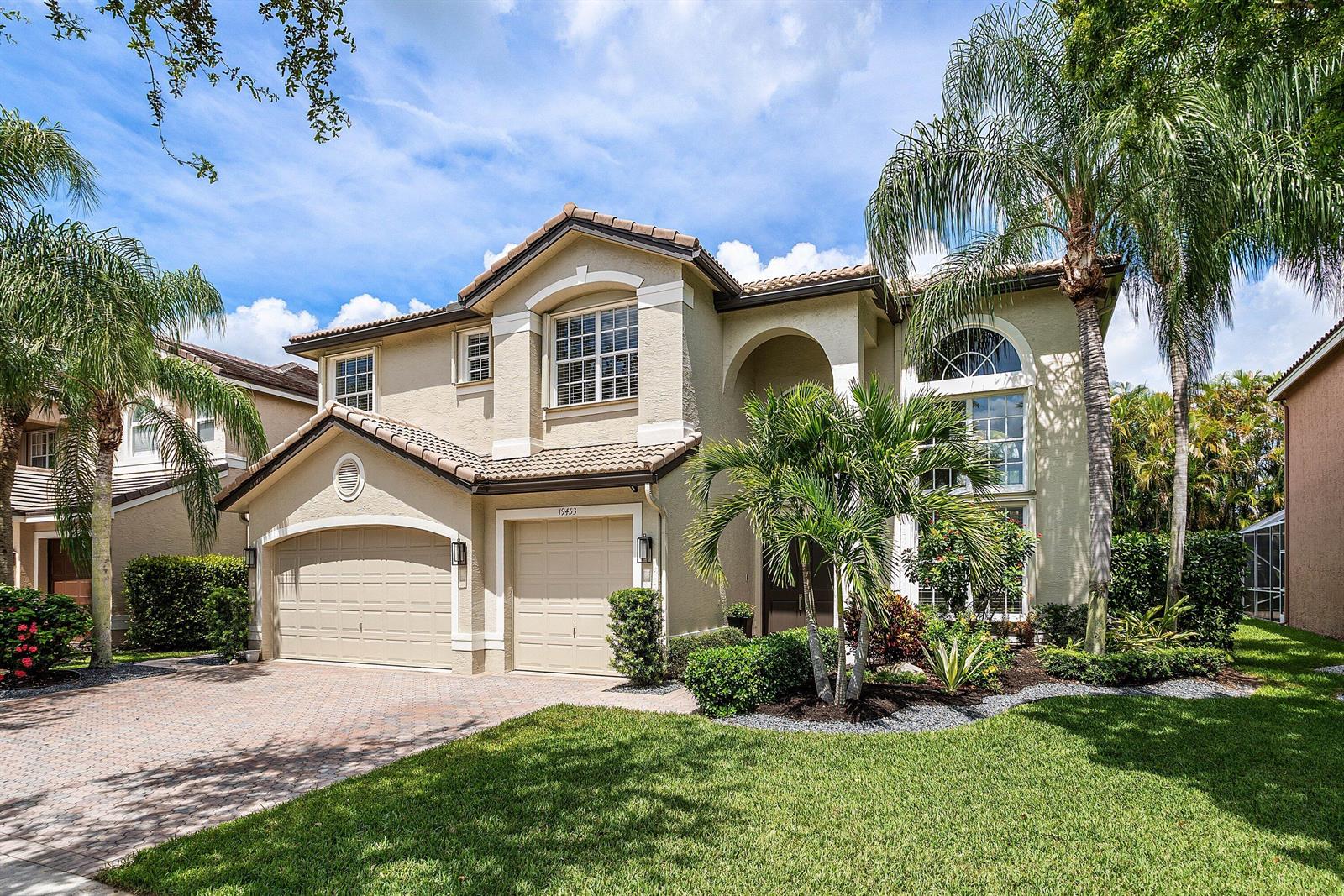 A two-story suburban house with a tan stucco exterior, tile roof, and two-car garage — 19453 Estuary Drive, Boca Raton FL 33498, BOCA RATON, FL