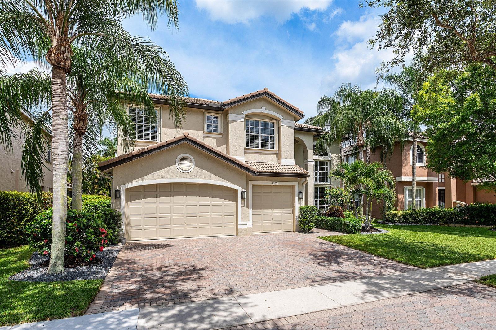 A two-story tan stucco house with a three-car garage and a paved driveway — 19453 Estuary Drive, Boca Raton FL 33498, BOCA RATON, FL