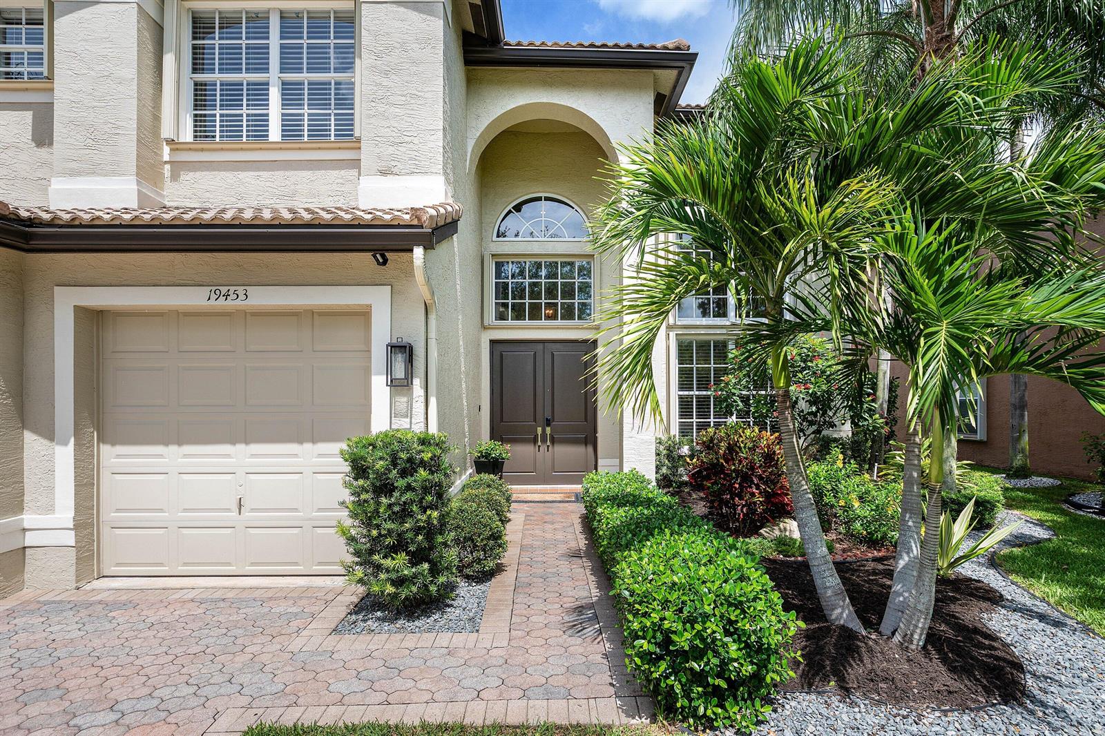 A two-story house exterior features a beige stucco facade, a garage, and a palm tree — 19453 Estuary Drive, Boca Raton FL 33498, BOCA RATON, FL