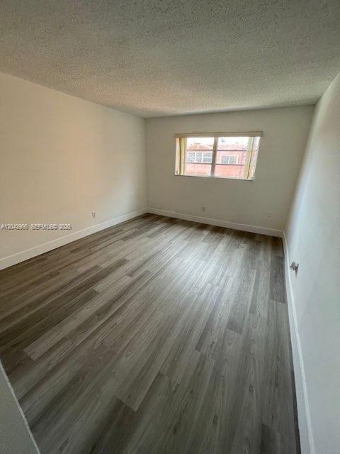 An empty bedroom features light gray wood-look flooring and a single window with blinds — 6125 W 20th Ave # 312, Hialeah FL 33012, HIALEAH, FL