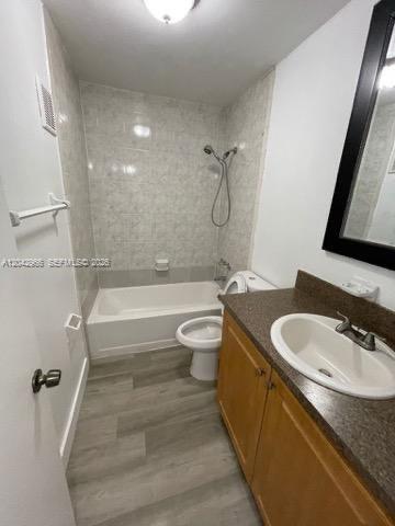 A bathroom features a vanity with a dark countertop, a toilet, and a shower-tub combo — 6125 W 20th Ave # 312, Hialeah FL 33012, HIALEAH, FL