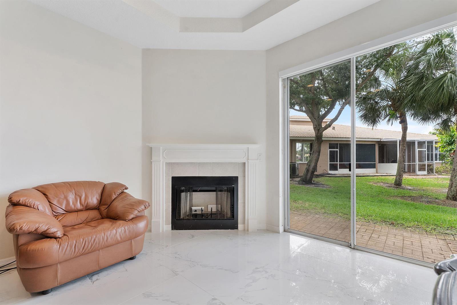 A dining area with a wooden table and chairs sits adjacent to a living room — 8541 Water Cay, West Palm Beach FL 33411, WEST PALM BEACH, FL