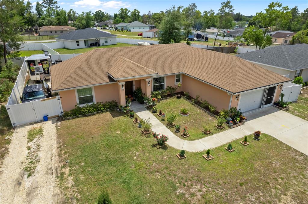 An aerial view of a single-story peach-colored house with a brown roof and front yard — 4406 SW 152ND STREET SW, OCALA, FL