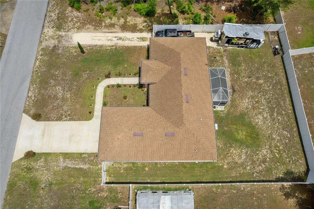 An aerial view shows a single-story house with a brown roof and a fenced backyard — 4406 SW 152ND STREET SW, OCALA, FL