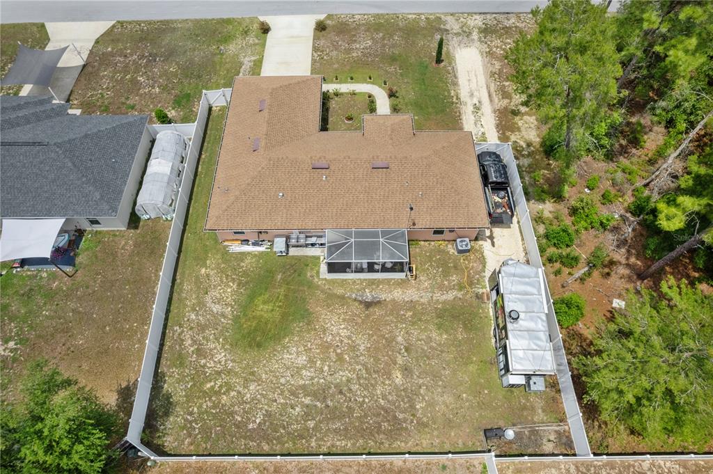 An aerial view shows a house with a brown roof, a screened porch, and fenced yard — 4406 SW 152ND STREET SW, OCALA, FL