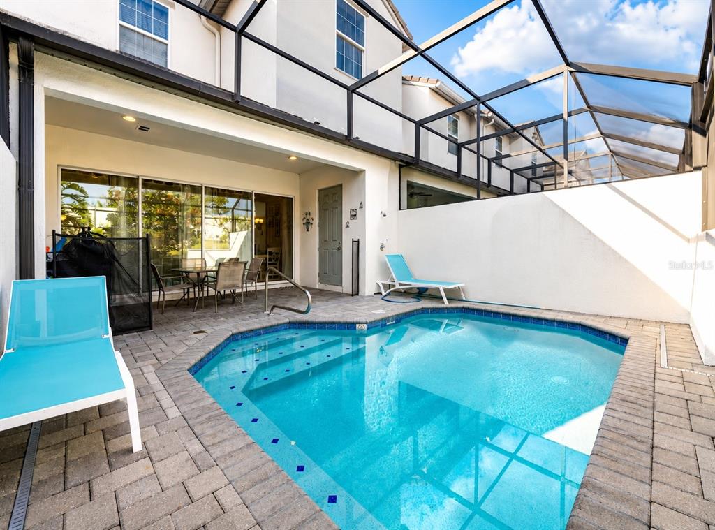 A screened-in patio features a small swimming pool, lounge chairs, and a paved deck — 354 CAPTIVA DRIVE, DAVENPORT, FL