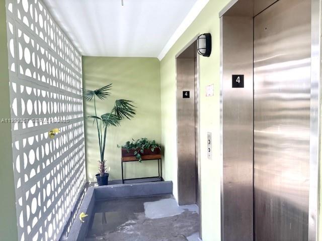 An elevator lobby with a decorative screen wall, a potted plant, and stainless steel doors — 1425 Arthur St # 403A, Hollywood FL 33020, HOLLYWOOD, FL