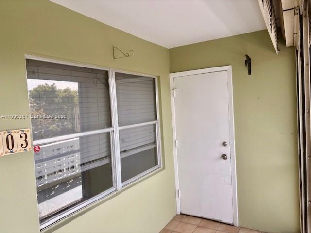 A light green enclosed porch features a white door and a large window with blinds — 1425 Arthur St # 403A, Hollywood FL 33020, HOLLYWOOD, FL