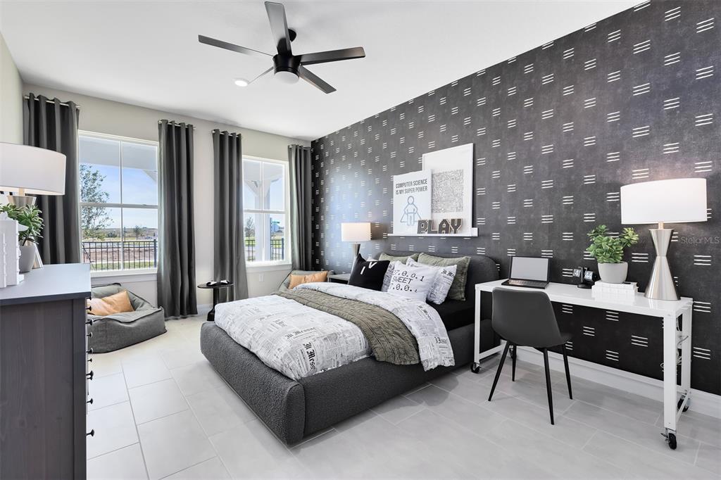 A bedroom features a patterned accent wall, a bed with gray bedding, and a desk — 346 CRYSTAL WOOD DRIVE, WINTER GARDEN, FL