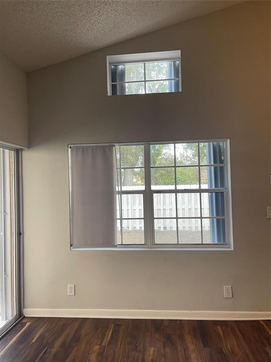 A room with dark wood flooring, a large window, a transom window, and sliding doors — 480 Somerset Way, Weston FL 33326, WESTON, FL