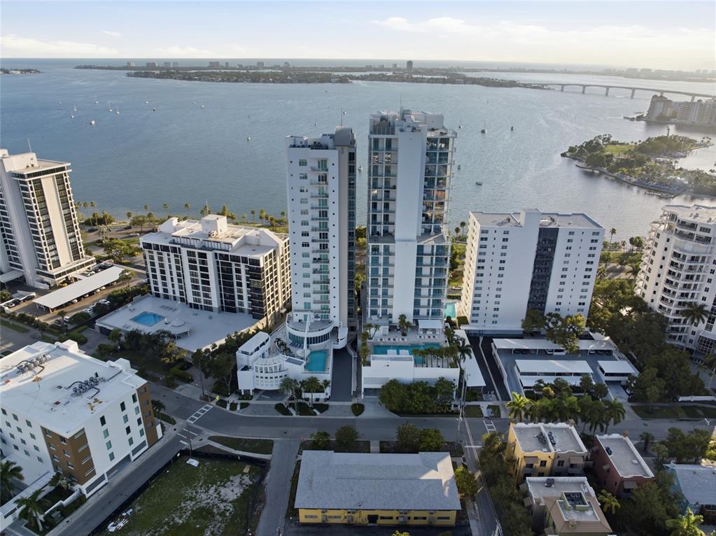 An aerial view shows several high-rise residential buildings situated along a waterfront with a bridge — 615 S PALM AVENUE UNIT 10, SARASOTA, FL