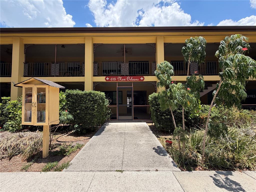 A concrete walkway leads to the entrance of a two-story apartment building with balconies — 615 S PALM AVENUE UNIT 10, SARASOTA, FL