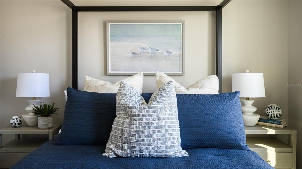 A bedroom features a bed with blue bedding and a framed print of birds — 31691 OYSTER TRELLIS LANE, WESLEY CHAPEL, FL