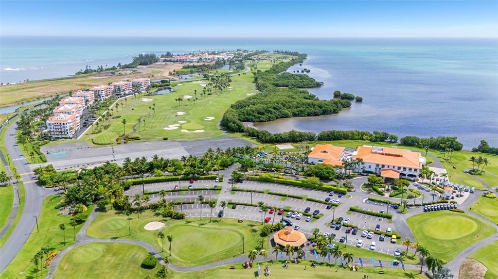 An aerial view shows a golf course, a parking lot, and buildings near the ocean — 400 COCO BEACH BOULEVARD UNIT G-301, RIO GRANDE, PR