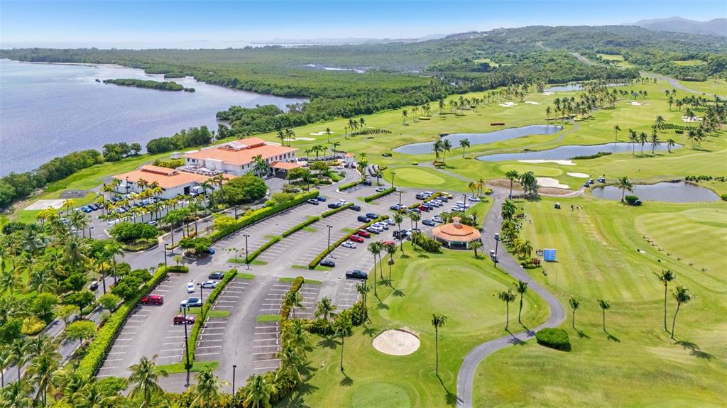 An aerial view shows a golf course clubhouse, parking lot, and surrounding green fairways — 400 COCO BEACH BOULEVARD UNIT G-301, RIO GRANDE, PR