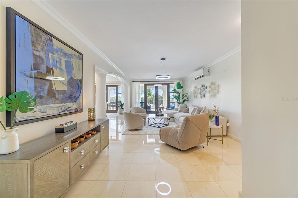 A bright, open-concept living room features light tile flooring, modern furniture, and a large wall painting — 400 COCO BEACH BOULEVARD UNIT G-301, RIO GRANDE, PR