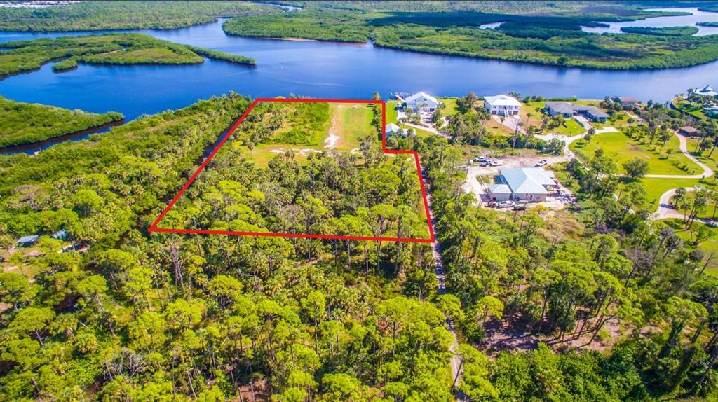 An aerial view shows a rectangular plot of land outlined in red near a waterway — DEER COURT, VENICE, FL