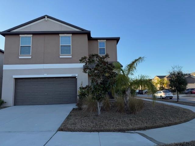 A two-story house with a tan stucco exterior and a two-car garage — 15501 WICKED STRONG STREET, SUN CITY CENTER, FL