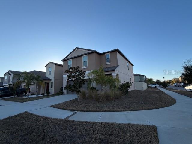 A two-story suburban house with a tan exterior and a concrete driveway — 15501 WICKED STRONG STREET, SUN CITY CENTER, FL