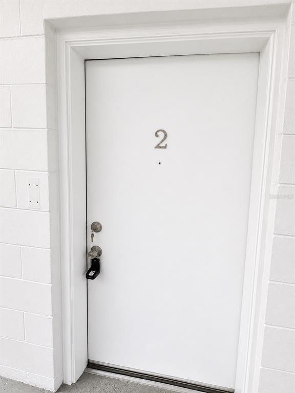 A white exterior door labeled with the number two features a lockbox on the handle — 1745-1745 NE 2ND STREET UNIT 2, OCALA, FL