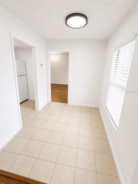 A tiled room features a ceiling light, a window with blinds, and two doorways — 1745-1745 NE 2ND STREET UNIT 2, OCALA, FL