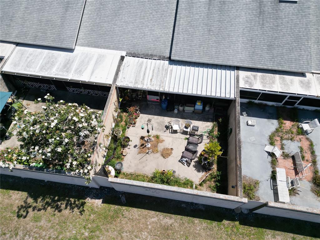 An aerial view shows a concrete patio with outdoor furniture and a large flowering tree — 4317 TIBURON DRIVE, NEW PORT RICHEY, FL