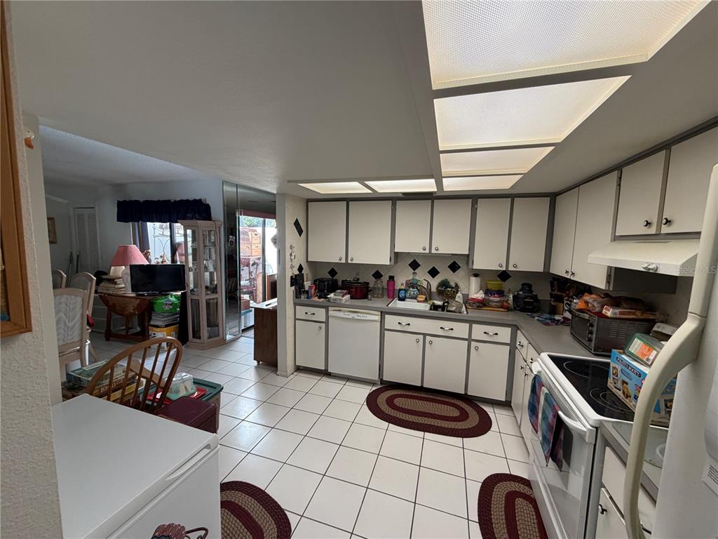 A kitchen with white cabinets, tiled floors, and a drop ceiling with recessed lighting — 4317 TIBURON DRIVE, NEW PORT RICHEY, FL