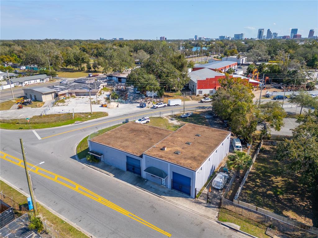 An aerial view shows a light-colored industrial building with two garage doors near a road — 41 N DOLLINS AVENUE, ORLANDO, FL