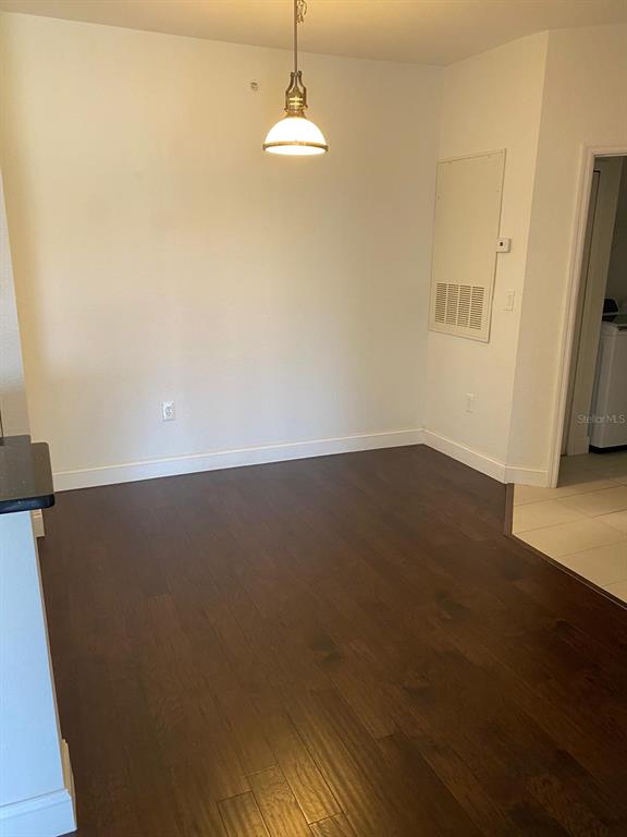 A living room with dark wood flooring, a ceiling fan, and sliding glass balcony doors — 5475 VINELAND ROAD UNIT 8311, ORLANDO, FL