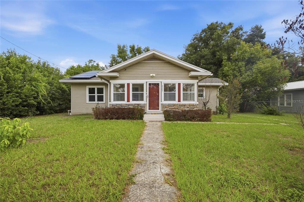 A single-story house with tan siding, a front porch, and a stone-accented facade — 2207 AVENUE F NW, WINTER HAVEN, FL