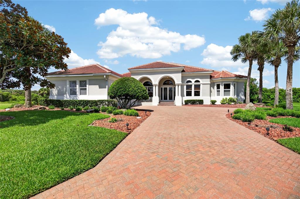 A single-story house with a red tile roof and a brick paver driveway — 32 SAN GABRIEL LANE, PALM COAST, FL