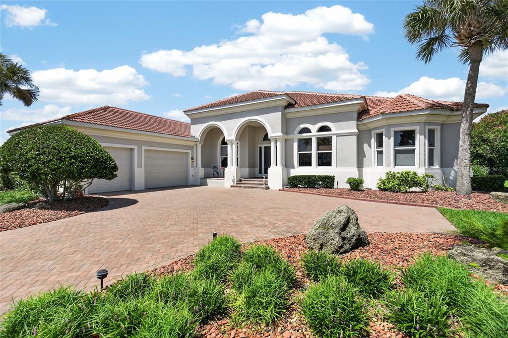 A single-story house with a tiled roof, arched entryway, and a paved driveway — 32 SAN GABRIEL LANE, PALM COAST, FL