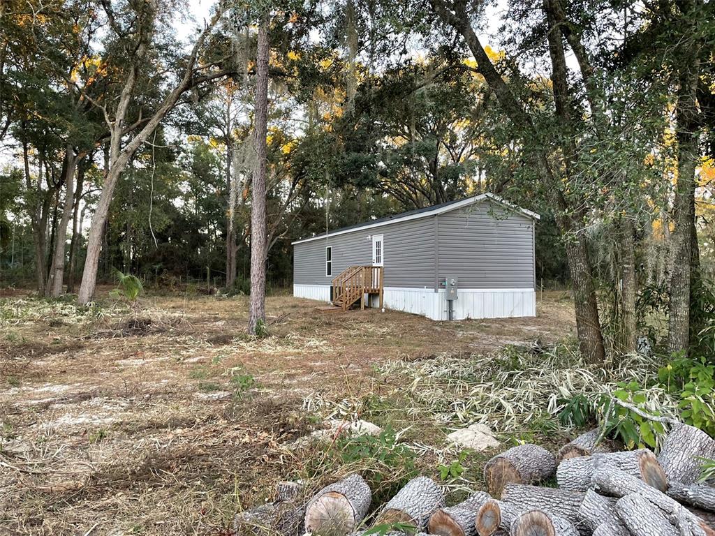 A bedroom with gray walls, dark carpeting, a single window, and two white interior doors — 11651 SE 82ND STREET, MORRISTON, FL