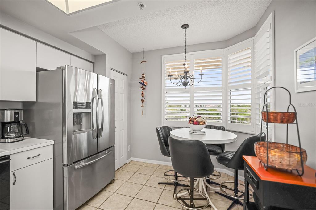 A kitchen features white cabinets, stainless steel appliances, and tile flooring — 6399 SHORELINE DRIVE UNIT 4305, ST PETERSBURG, FL