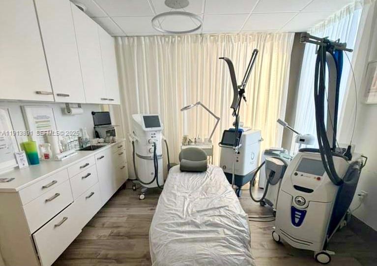 A medical aesthetic treatment room features a procedure bed and various specialized laser equipment — 2500 E Hallandale Beach Blvd, Hallandale Beach FL 33009, HALLANDALE BEACH, FL