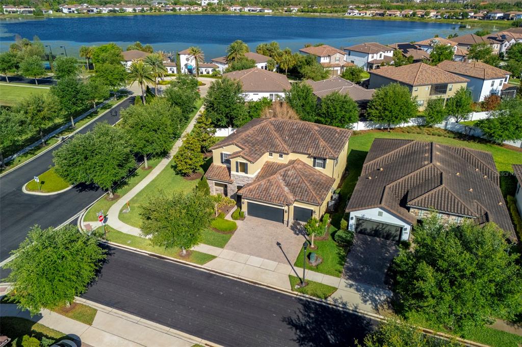 An aerial view shows two suburban houses with tile roofs near a large lake — 10950 CITRON OAKS DRIVE, ORLANDO, FL