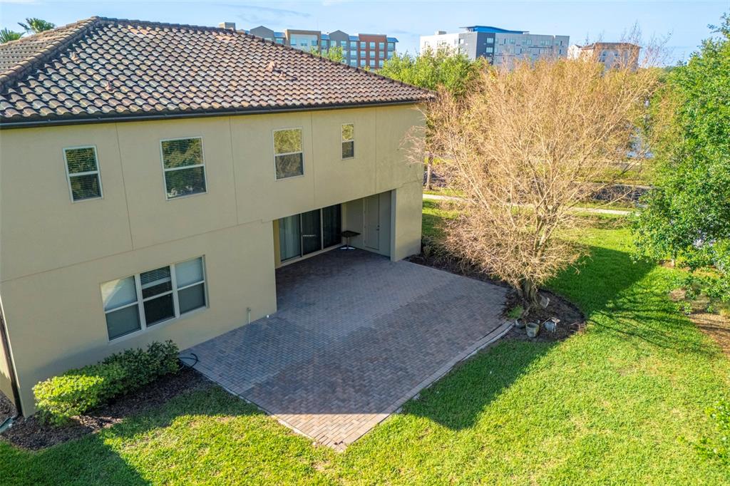 An aerial view of a two-story house exterior with a paved patio and backyard — 10950 CITRON OAKS DRIVE, ORLANDO, FL
