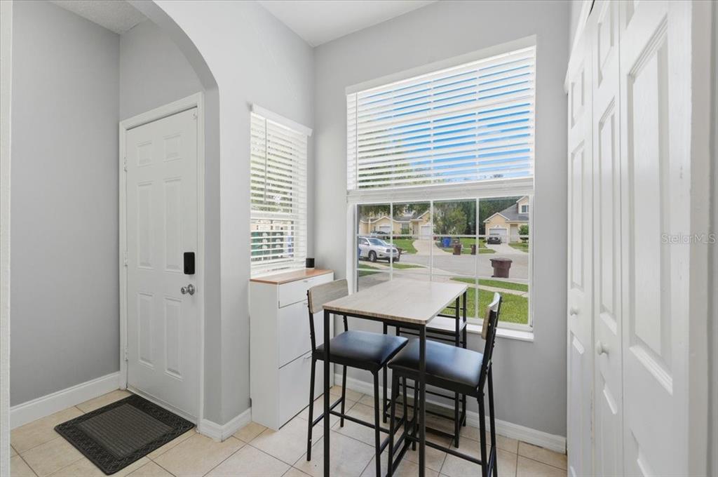 A small dining area features a high-top table, two stools, and a window view — 2446 TEMPLE GROVE LANE, KISSIMMEE, FL