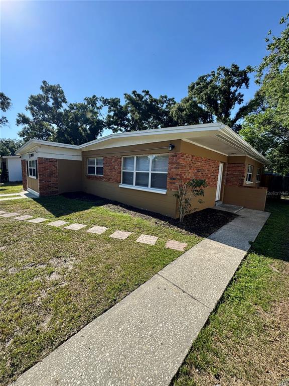 An empty room with tan tile flooring, beige walls, and a ceiling fan — 2016 E CRENSHAW STREET, TAMPA, FL