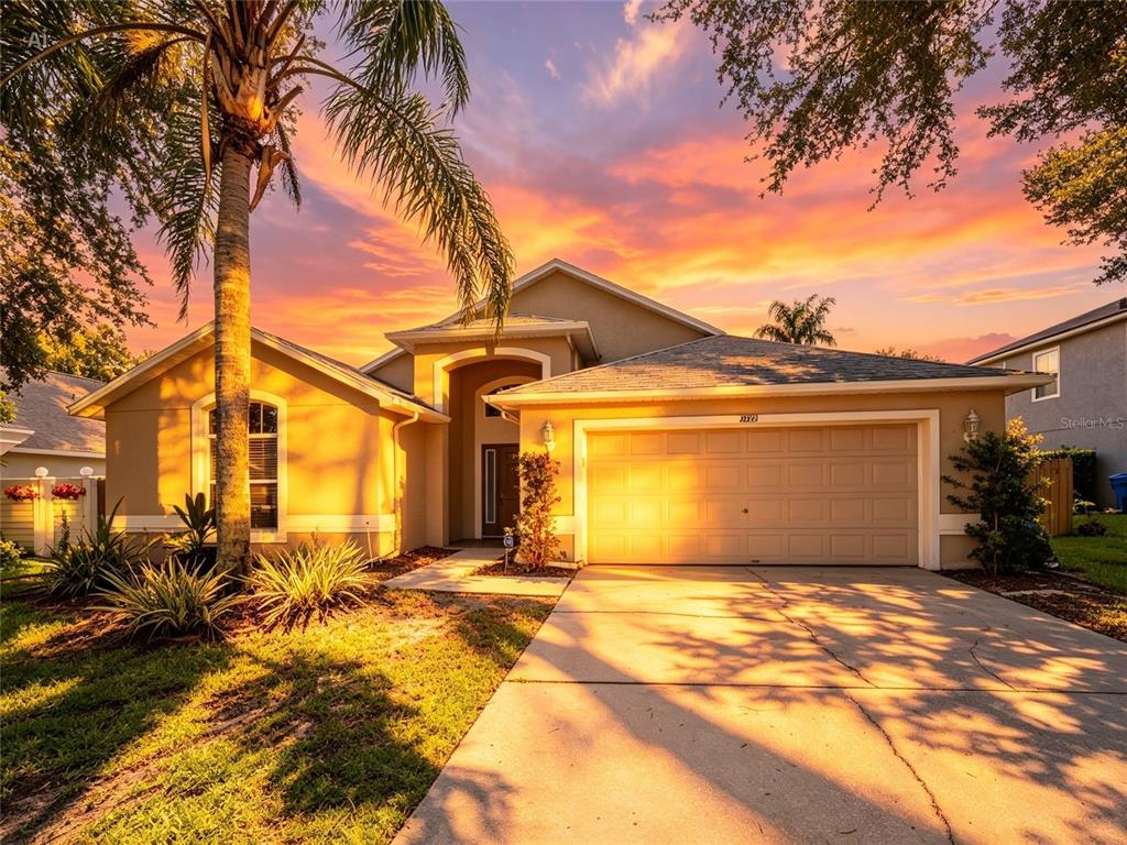 A single-story house with a two-car garage and a palm tree at sunset — 2843 STRAND CIRCLE, OVIEDO, FL