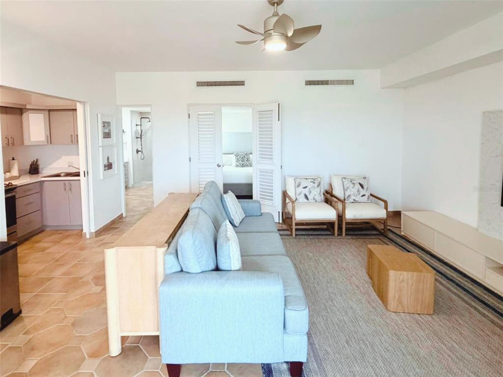 A living room features a blue sofa, two armchairs, a wooden coffee table, and tile flooring — 1000 LAS CASITA I, EL CONQUISTADOR AVE. UNIT 5380, FAJARDO, PR