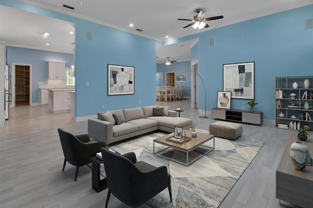 A spacious living room with light blue walls, gray flooring, and modern furniture — 2590 ERENA DRIVE, NEW SMYRNA BEACH, FL