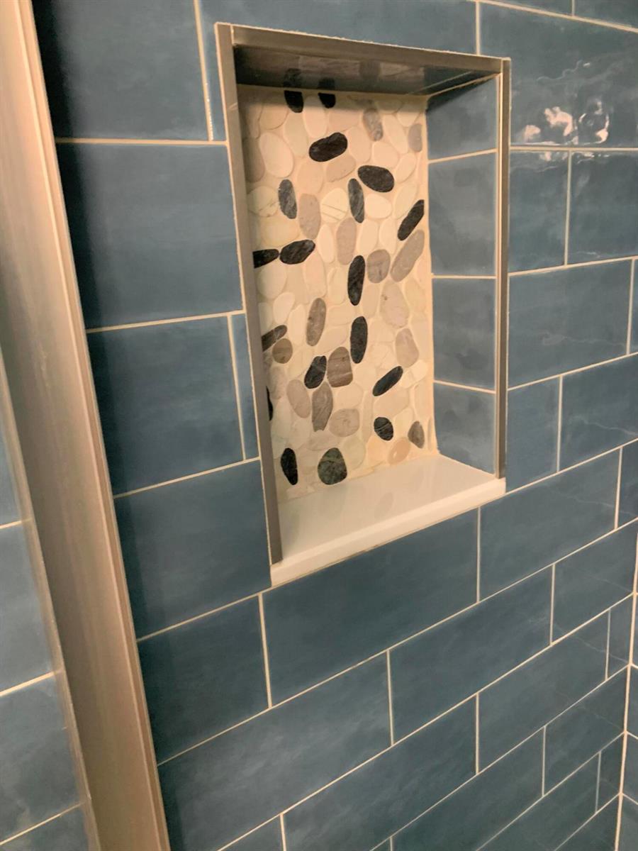 A shower wall features blue subway tiles and a recessed niche with pebble tile accents — 100 S South Boulevard # 1c, Boynton Beach FL 33435, BOYNTON BEACH, FL