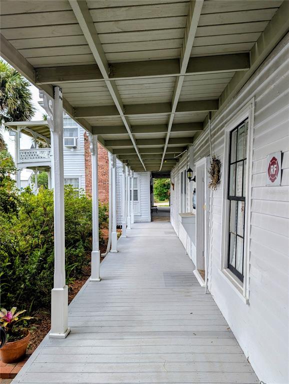 A long, covered wooden porch runs along the side of a white clapboard building — 6635 SE 221ST STREET UNIT 3, HAWTHORNE, FL