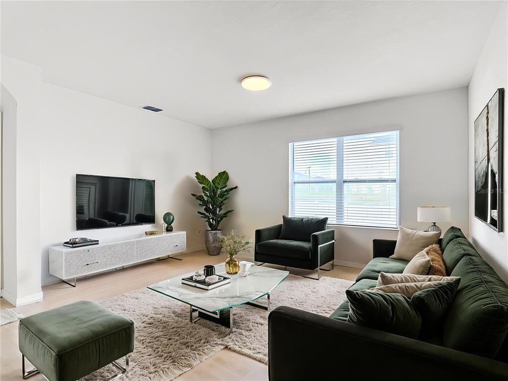 A living room features a green sofa, a marble coffee table, and a white media console — 2352 WHITE POPPY DRIVE, KISSIMMEE, FL