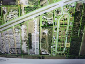 This is an aerial map showing a vacant lot highlighted in yellow near a residential street — 2122 PINEGROVE CIRCLE, PUNTA GORDA, FL