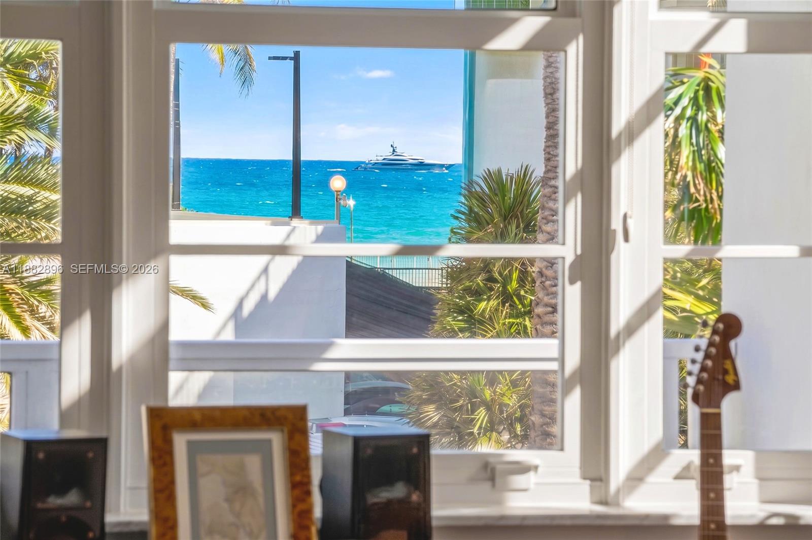 A view of the ocean and a yacht seen through a window from indoors — 5700 Collins Ave # 3M, Miami Beach FL 33140, MIAMI BEACH, FL