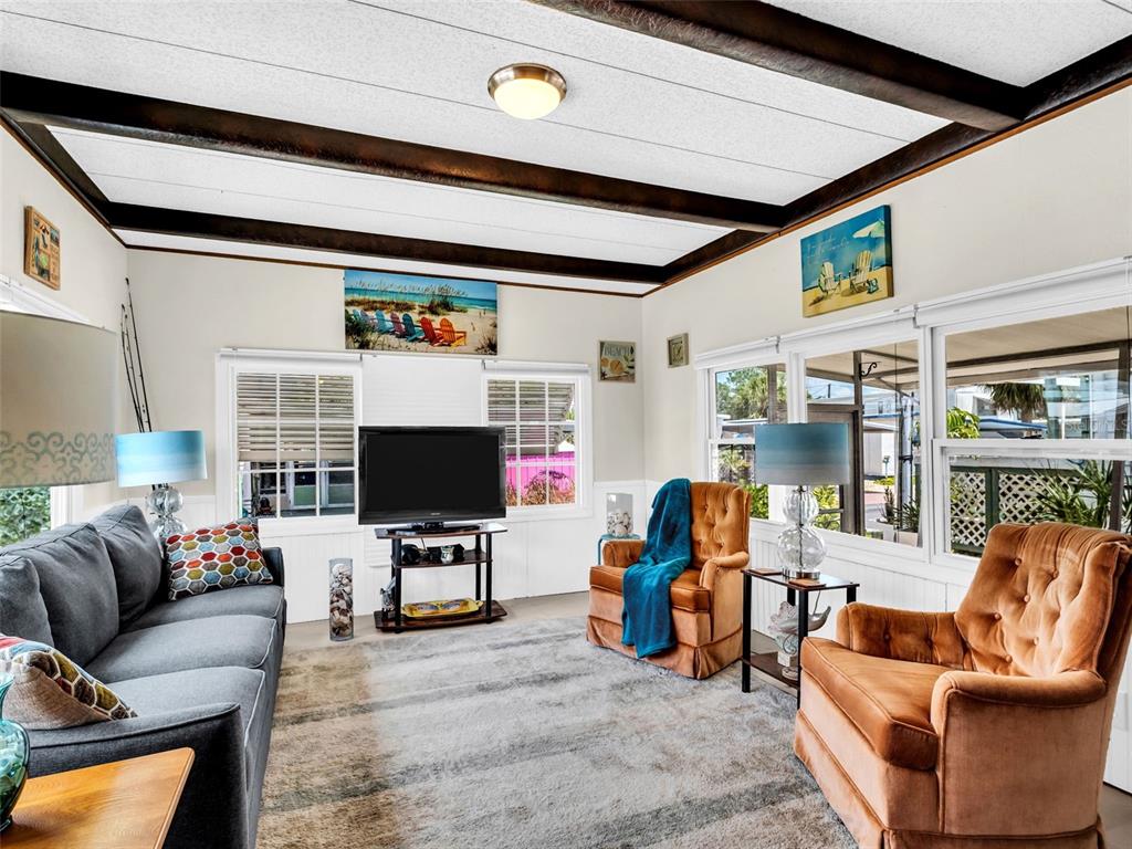 A living room features a gray sofa, two brown armchairs, and a television on a stand — 800 CHESAPEAKE DRIVE UNIT 62, TARPON SPRINGS, FL