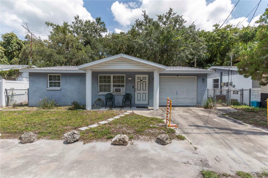 A single-story gray house with a front porch, attached garage, and a concrete driveway — 8431 SUNNYDALE DRIVE, HUDSON, FL