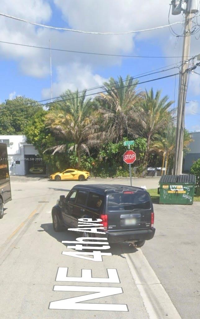 A black SUV is parked at an intersection with a yellow sports car nearby — 361 NE 69th St, Miami FL 33138, MIAMI, FL